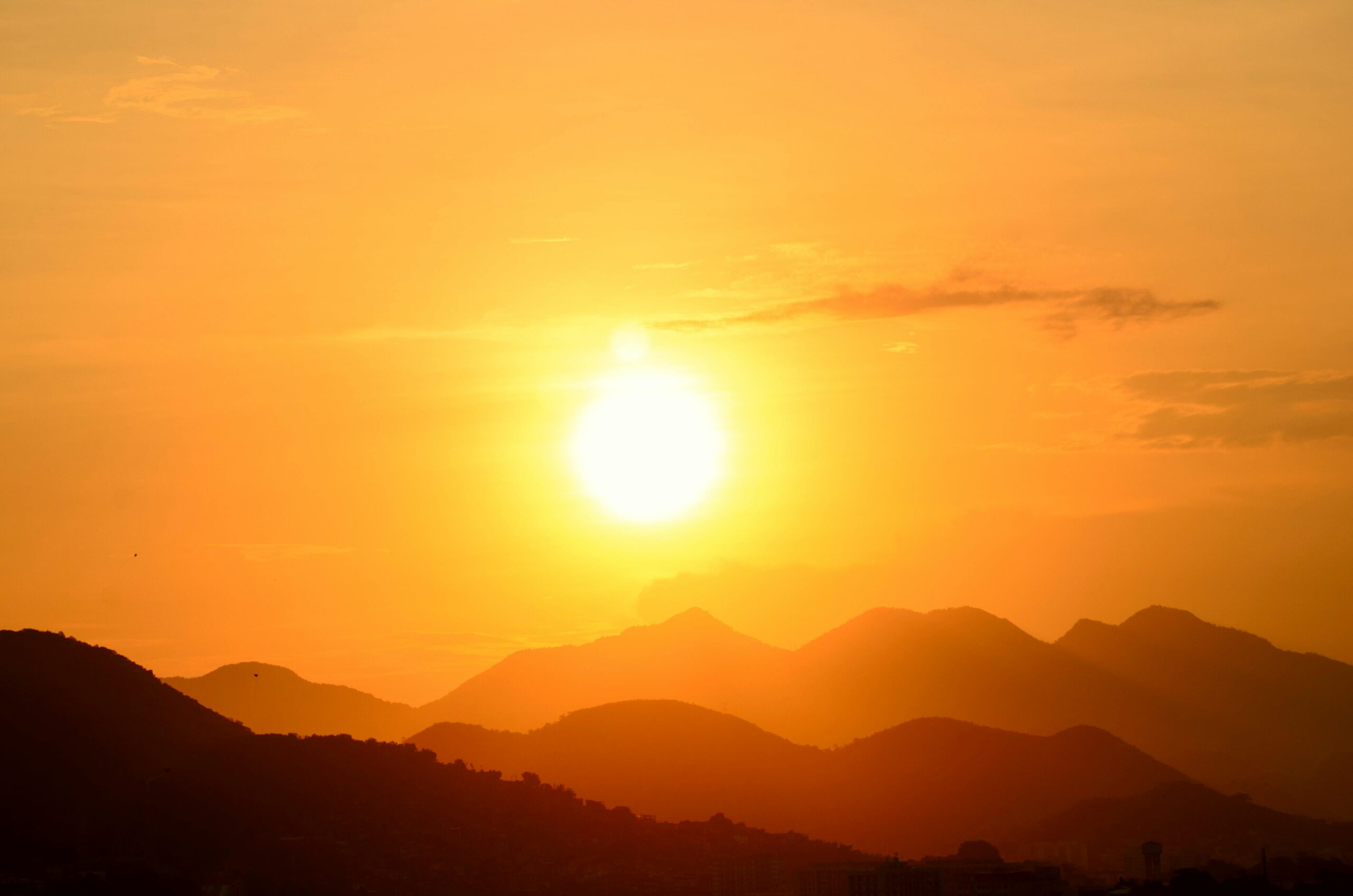 Stunning sunset over Rio de Janeiro's mountains, capturing the vibrant golden hues and silhouettes.
